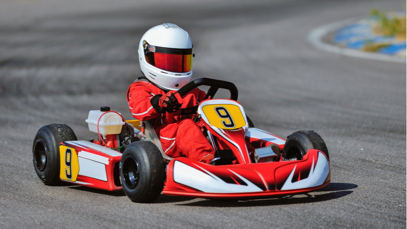 a child racing a go kart on a professional track