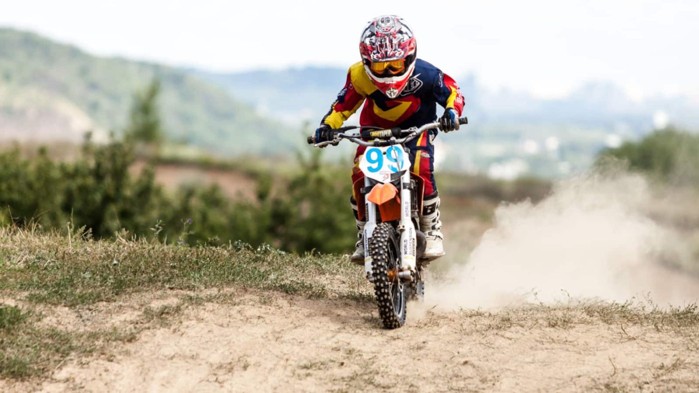 Child riding a dirt bike on a dirt track